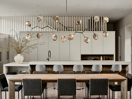 Sleek, modern kitchen with geometric pendant lighting and minimalist dining table.