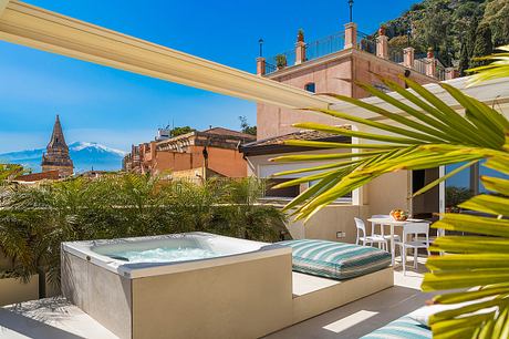 Luxurious rooftop terrace with hot tub, outdoor seating, and stunning architectural views.
