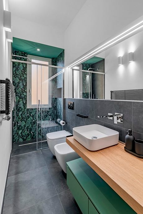 Contemporary bathroom with sleek glass shower, natural wood vanity, and bold green accents.