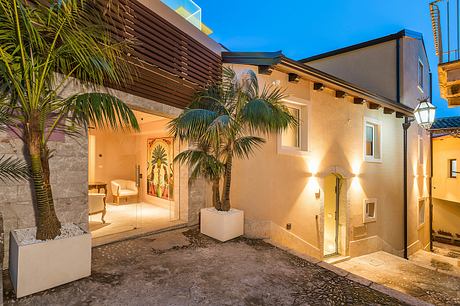 Warm, inviting architecture with tropical palm accents and carved wood details.