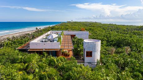 Tropical beachfront villa with modern concrete architecture and wooden decks.