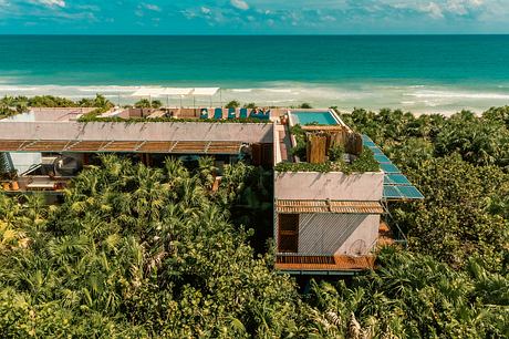 A sprawling tropical resort with a pool, cabanas, and lush greenery surrounding the buildings.