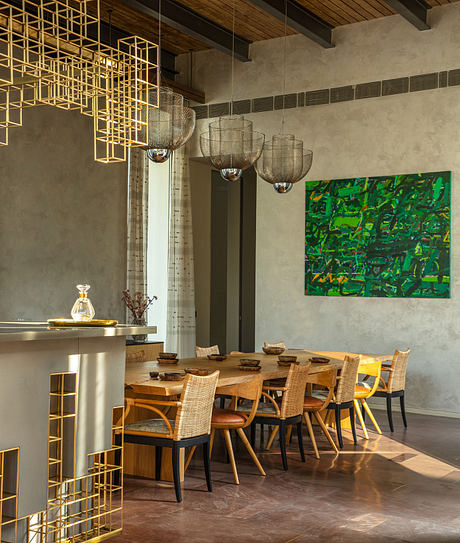 Striking metallic geometric fixtures, rustic wooden table, and vibrant abstract art create a warm, modern ambiance.