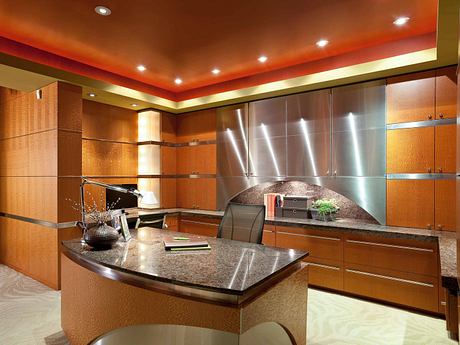 A modern kitchen with sleek wood cabinetry, granite countertops, and recessed lighting.