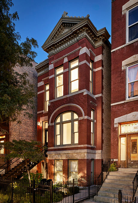 Ornate brick facade with arched windows, decorative details, and stone steps leading up to the entrance.