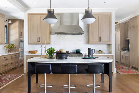 Spacious, light-filled kitchen with neutral cabinetry, marble countertops, and a large central island.