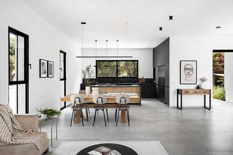 Spacious open-plan kitchen-dining area with clean lines, bold contrasts, and natural elements.