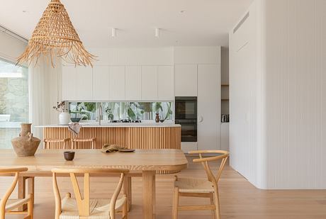 Bright, minimalist kitchen with modern wood furnishings and a striking woven pendant light.