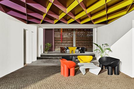 Vibrant geometric ceiling contrasts with rustic wood walls in modern interior design.