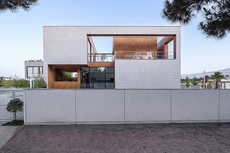 Modern minimalist residential building with wooden accents, glass, and concrete facade.