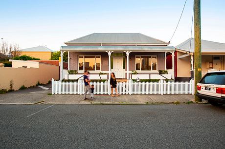 Typical Australian suburban house with Edwardian architectural style, porch, and white picket fence.