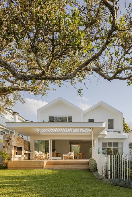A modern, minimalist home with a large covered patio, stone fireplace, and landscaped garden.