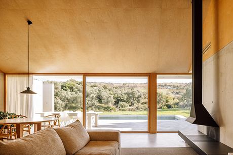 Large floor-to-ceiling windows offer panoramic views of the lush, rolling landscape.