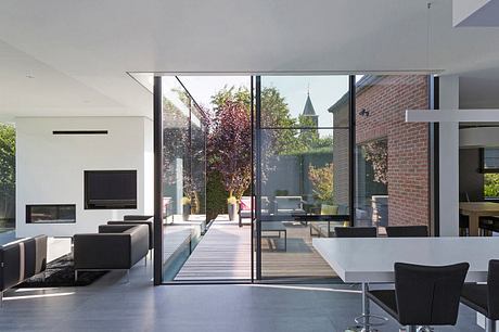 Modern glass and brick home with seamless indoor-outdoor flow and serene garden view.