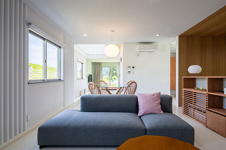 Bright, modern living room with a gray sofa, wooden furniture, and a panoramic window.