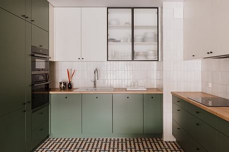 Sleek, modern kitchen with olive green cabinets, wooden countertops, and frosted glass dividers.