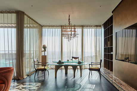 Elegant dining area with modern chandelier, glass-top table, and contemporary seating.