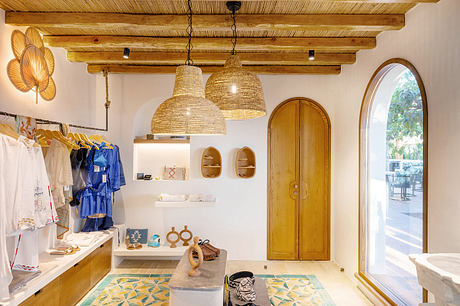 Rustic wooden beams, pendant lights, and arch-topped doorway in a cozy retail space.