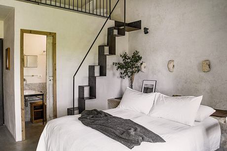 Minimalist bedroom design featuring a modern staircase, plants, and neutral tones.