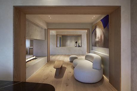 Spacious modern living room with warm wooden accents, plush seating, and minimalist artwork.
