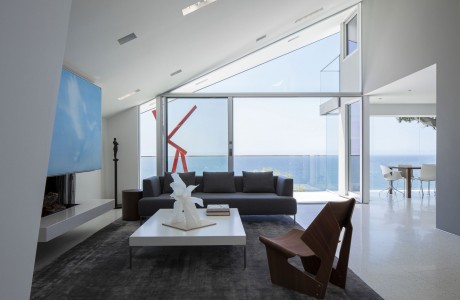 Minimalist modern living room with expansive ocean view, angular architectural details.