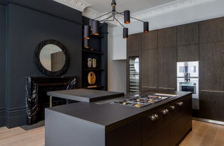 Elegant kitchen with dark wood cabinetry, sleek countertops, and sophisticated lighting.