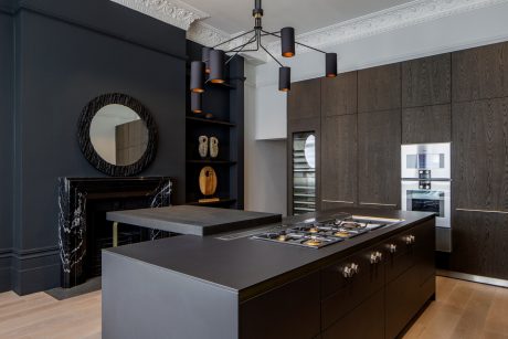 Elegant kitchen with dark wood cabinetry, sleek countertops, and sophisticated lighting.