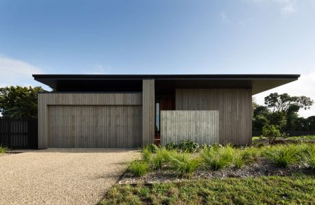 A modern, single-story house with a flat roof and clean, minimalist design.