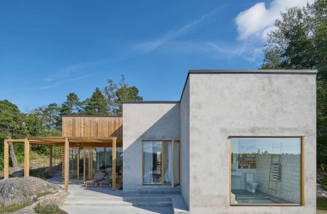 Contemporary home with concrete finish and wooden accents in a natural setting.