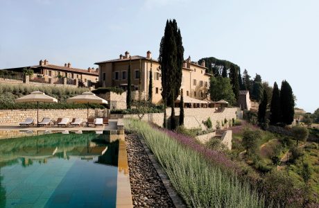 Picturesque Tuscan villa with stone facade, landscaped gardens, and tranquil pool.