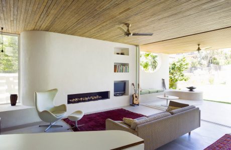 Spacious living room with wood-paneled ceiling, fireplace, and modern furniture.