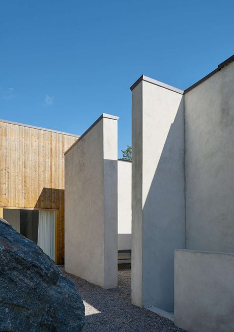 Modern building exterior with angular walls and wooden paneling under blue sky.