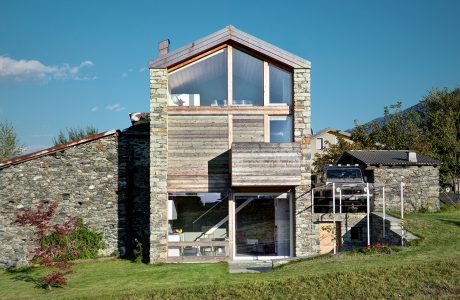 A striking modern cabin with extensive use of stone, wood, and glass elements.