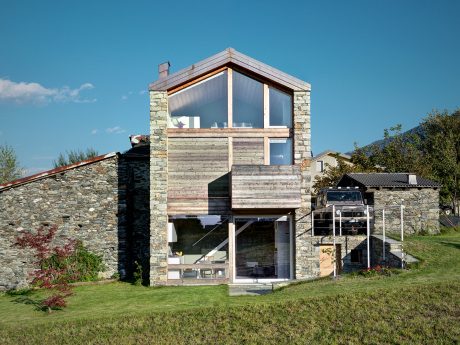 A striking modern cabin with extensive use of stone, wood, and glass elements.