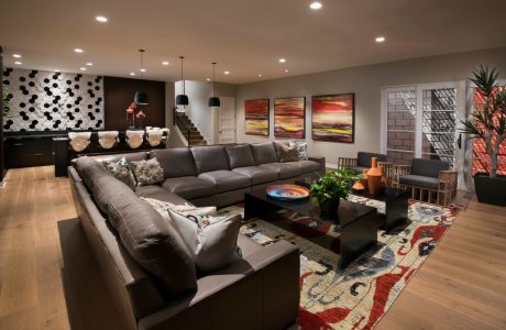 Spacious living room with modern furnishings, vibrant artwork, and architectural details.