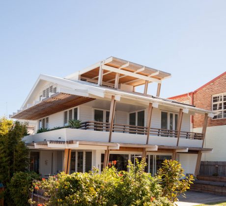 Striking modern architecture with multilevel wooden deck and slanted roof design.