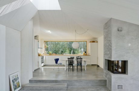 Modern kitchen with concrete floor, large window, and fireplace.