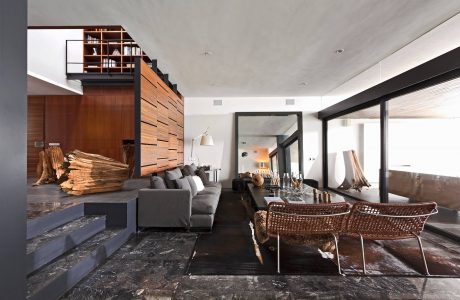 Striking modern interior with sleek wooden wall panels, grey seating, and rustic accents.