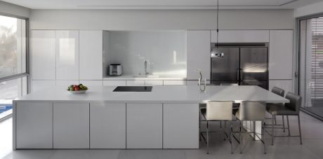 Sleek, minimalist kitchen with gray cabinets, stainless steel appliances, and large windows overlooking outdoor scenery.