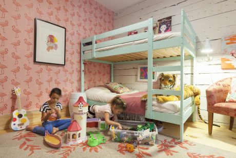 A cozy, vibrant children's bedroom with a bunk bed, playful wallpaper, and whimsical decor.