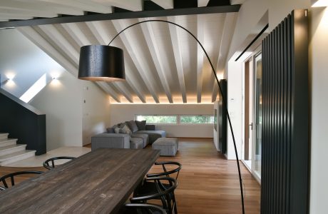 Spacious modern open concept living area with high ceilings, wood beams, and recessed lighting.