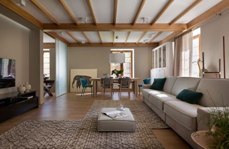 Cozy living space with wooden beams, neutral tones, and contemporary furnishings.