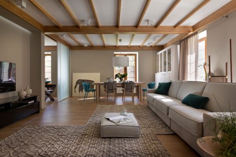 Cozy living space with wooden beams, neutral tones, and contemporary furnishings.