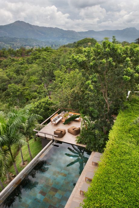 Stunning outdoor seating area overlooking lush tropical forest and mountains.