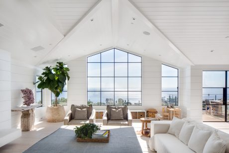 Airy living room with high ceilings, large windows, and natural textures throughout.