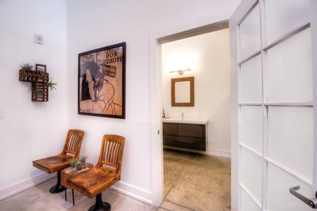 Rustic chairs flank a framed Don Quixote poster in this well-designed entryway.