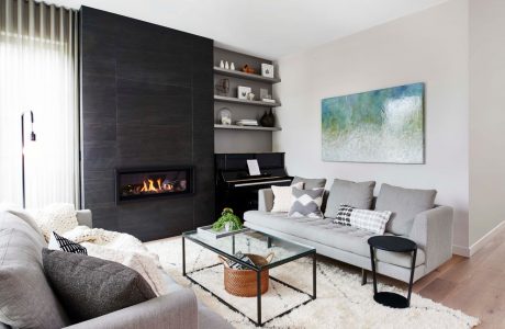 Modern living room with sleek fireplace, built-in shelves, and abstract artwork.