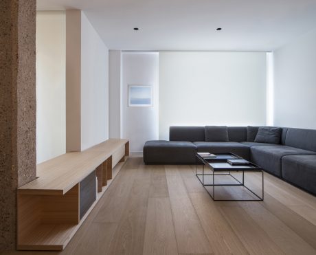 Airy, minimalist living space with clean lines, wooden flooring, and modern furnishings.