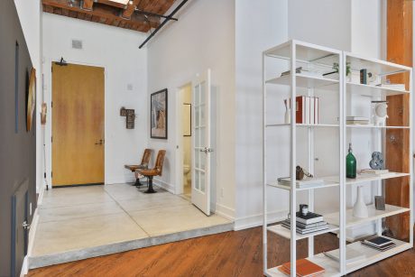 Interior with wooden beams, shelving unit, and concrete flooring creating modern, industrial look.