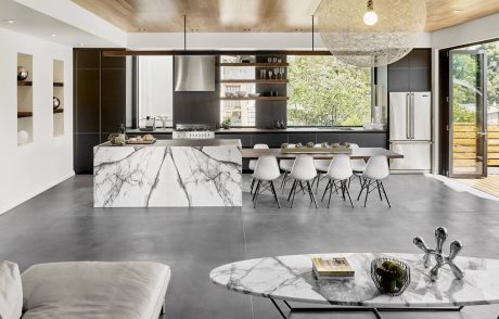 Spacious, modern kitchen with marble island, hanging light fixture, and clean lines.